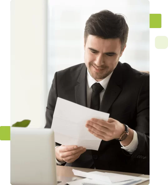 Homem branco vestido terno segurando uma folha de papel